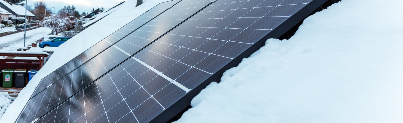 american house with solar panels during winter snow storm